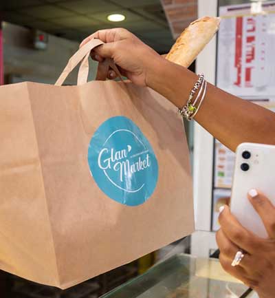 Photo d'une femme récupérant son Glan'Bag en boulangerie