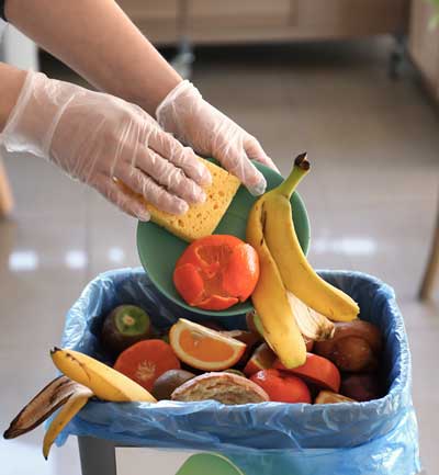 Photo d'une serveur de café jetant des aliments à la poubelle